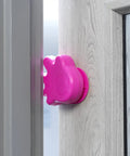 Anti Slam Door Finger Trap Stoppers For Kids 2 Pack Pink Easy Adhesive Install Durable Plastic C Shaped Guards To Prevent Pinched Fingers At Doors Safe Home Baby Proofing For Busy Families showing one pink stopper on a wooden door frame
