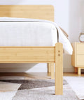 Natural Bamboo King Size Platform Bed Frame With Headboard features a close-up view of the sturdy wood legs and mattress.