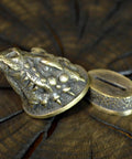 Close-up of bronze dragon-themed pommel from Finger Guard Knife Making Kit With Bolster And Pommel For Custom Blades Hand Cast Bronze Dragon Set Dope DIY Knife Maker Gear With Solid Bronze Dragon Casts And Handy Handle Components Moose Hunting Themed Accessories.