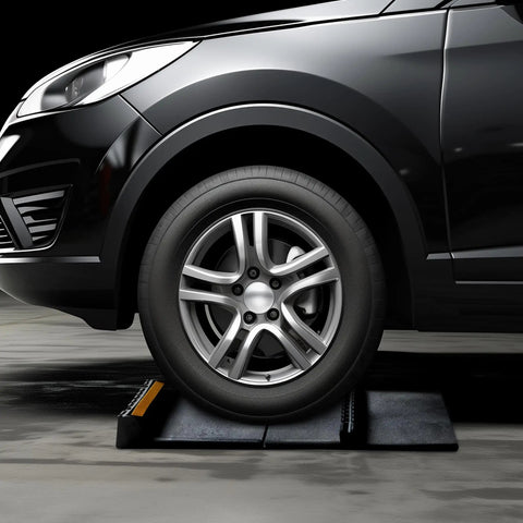 Vehicle parked on Heavy Duty Rubber Parking Stop for Garage Floors 2 Pack Vehicle Wheel Stop with Reflective Yellow Targets installed in garage.