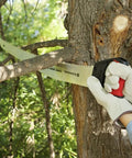 Person using 18 Inch RazorTOOTH Pruning Saw With Curved Blade And D Handle for gloved two-handed use on thick tree branch