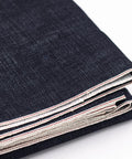 16oz Heavyweight Selvedge Denim Fabric 100 Percent Cotton Raw Indigo showing folded shuttle loom woven edges and narrow width.