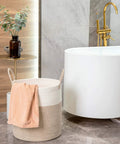 Huge Cotton Rope Storage Basket 18 By 16 Inches Decorative Woven Laundry Hamper next to a bathtub with a towel, in a bathroom setting.
