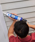 Person applying Clear Silicone Caulk Sealant For Indoor And Outdoor Use, 100 Percent Waterproof, Weatherproof And Flexible, on siding.