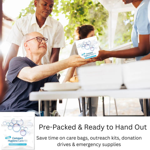 Volunteer handing Travel Laundry Kit to man at a community event outdoors.