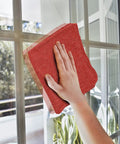 Red Linen Cotton Shop Towels Pack Of 150, 14 By 14 Inches Absorbent Cleaning Rags For Auto Shops, Garages, Industrial Jobs, And Home Use, Reusable Washable Multipurpose Lint Free being used to clean a window