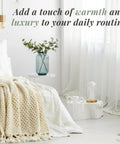Cozy bedroom with knit blanket, white curtains, and a plant on nightstand. Countertop Towel Warmer With Stainless Steel Bucket for Spa and Bathroom.