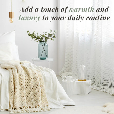 Cozy bedroom with knit blanket, white curtains, and a plant on nightstand. Countertop Towel Warmer With Stainless Steel Bucket for Spa and Bathroom.