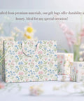 Two Large 13 Inch Floral Gift Bags With Matching Tissue Paper Card And Envelope Set Hand Painted Bloom Design Totally Perfect For Any Occasion Great For Women Gifts And Special Occasions displayed in a floral setting.