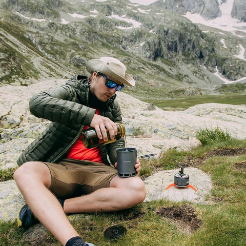 Man using Ultralight 600ml Camping Pot With Heat Exchanger And Lid, Foldable Portable Outdoor Gear For Hiking And Travel, Lightweight 162g, G3 Petrel Style High Efficiency Camp Pot in mountains