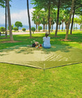 Ultralight Waterproof Tent Footprint Ground Sheet for Camping in park setting with person seated on green tarp, square shape.
