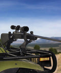 Rifle mounted on Single ATV Gun And Bow Rack For Handlebar Mounts, Fits Five Eighths To One Inch Tubular Bars, outdoors view