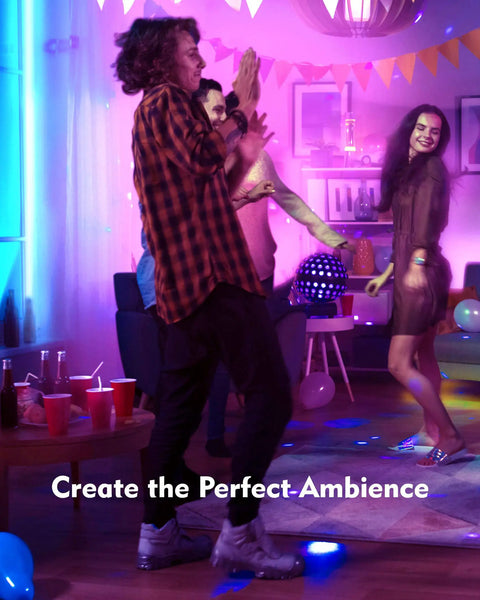 Group of friends dancing at a party with colorful lights and decorations creating a lively atmosphere in a living room.
