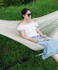 Person relaxing on Mayan Style Handwoven Rope Hammock For Two With Carry Bag Cozy 120 Inch Long By 67 Inch Wide Bed 500 Pound Capacity