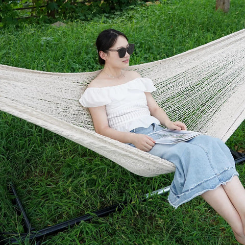 Person relaxing on Mayan Style Handwoven Rope Hammock For Two With Carry Bag Cozy 120 Inch Long By 67 Inch Wide Bed 500 Pound Capacity