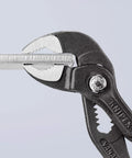 Cobra Water Pump Pliers 6 Inch With Self Locking Teeth And Pinch Guard For Safe Grip gripping a metal piece
