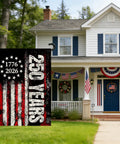 Patriotic 250th Anniversary USA Garden Flag displayed outside a house, showing stars and stripes with "250 Years" and "1776-2026" text.