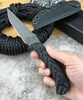 Hand holding Fixed Blade Knife With D2 Steel Blade, Textured G10 Handle, and Kydex Sheath for Safe Carry, near coiled rope.