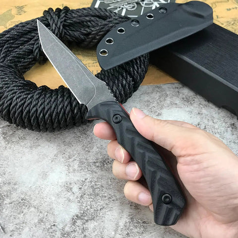 Hand holding Fixed Blade Knife With D2 Steel Blade, Textured G10 Handle, and Kydex Sheath for Safe Carry, near coiled rope.