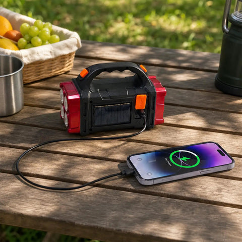 Solar Handheld Flashlight With Four Lighting Modes Rechargeable LED Work Light USB C Enabled charging phone outdoors on table