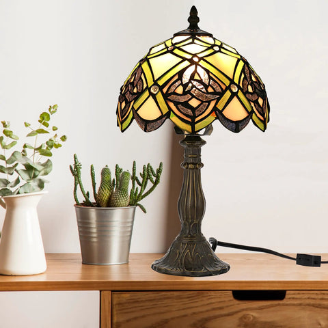 Irish Celtic Tiffany Style Stained Glass Table Lamp With 17500 Lumen Light, bronze metal base on wooden desk with plants.