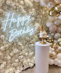 Lit Happy Birthday Neon Sign LED Light for Parties and Home Decor with floral wall and cake, 23.6 by 16.53 inches