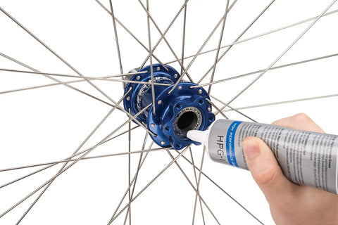 Applying HPG-1 High Performance Bicycle Grease 113 g to a bike hub for smooth, quiet ride, blue pro-grade lube for precision bearings.