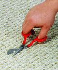 Hand using Duckbill Napping Carpet Shears 6 Inch With Offset Handle And Chrome Blades Vinyl Coated Grips on carpet