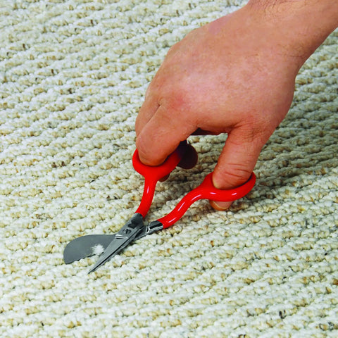 Hand using Duckbill Napping Carpet Shears 6 Inch With Offset Handle And Chrome Blades Vinyl Coated Grips on carpet