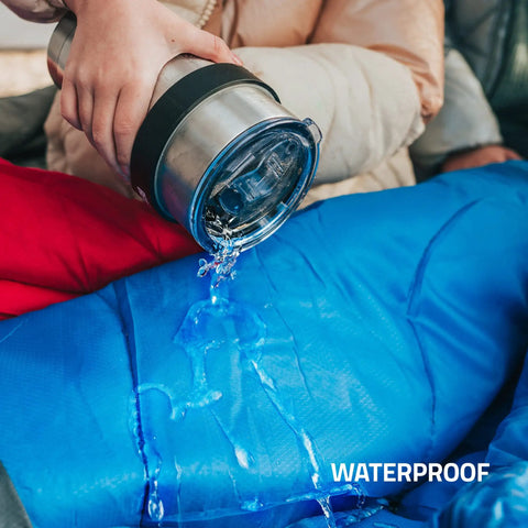 Person pouring water on blue waterproof All Season Sleeping Bag For Adults And Kids, Lightweight And Cozy Waterproof Gear For Backpacking Camping And Hiking, Temperature Rated 50F To 77F, Fits 6ft Adults, Single Or Double Comfort, Must Have Outdoor Sleep Gear