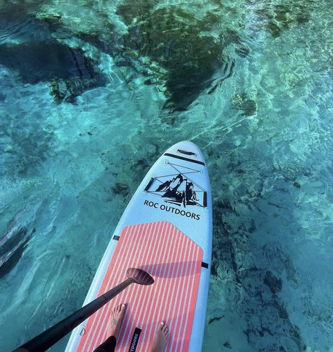 Top view of Inflatable Stand Up Paddle Board 10 Ft 6 In with premium SUP paddle on clear water.