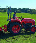 Farmer operating Kubota tractor on a field