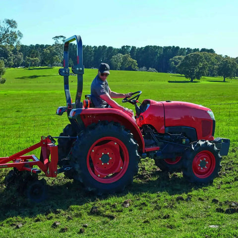 Farmer operating Kubota tractor on a field