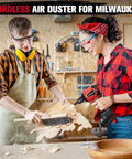 Two people using Cordless Air Blower Dust Duster For Milwaukee 18V, workshop setting, woodwork project cleaning.