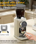 Next Level Electric Burr Coffee Grinder With 34 Dead Simple Settings And 40 Millimeter Stainless Steel Conical Burrs For Smooth Daily Brews In Clean White Setup with metal handle bracket and coffee grounds.