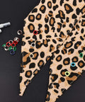 Colorful Grommet And Eyelet Kit with 680 pieces in 17 colors on leopard print fabric for DIY projects