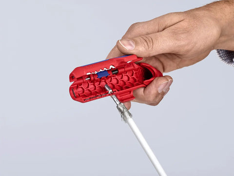 Hand using Workhorse Ergostrip Cable Stripping Tool with ergonomic pistol grip on damp-proof data cable