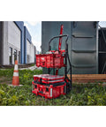 Red Beast Mode Heavy Duty Packout Large Tool Box With IP65 Weather Seal outdoors, stacked on a trolley next to a building and cone.