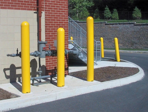 Straight Up Heavy Duty Yellow Bollard Post Cover 48 Inch Height By 6.5 Diameter Low Density Polyethylene Thermoplastic Guard For Parking Lots positioned near building.