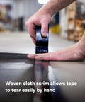 Close-up of hand tearing Heavy Duty Black Duct Tape 1.88 Inch By 60 Yard 3 Pack Industrial Strength Tear By Hand Multi Use