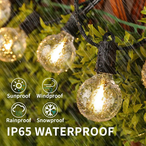 G40 Globe LED Outdoor String Lights 100 Ft IP65 Waterproof Weatherproof with 52 Shatterproof Bulbs shown in rain on greenery