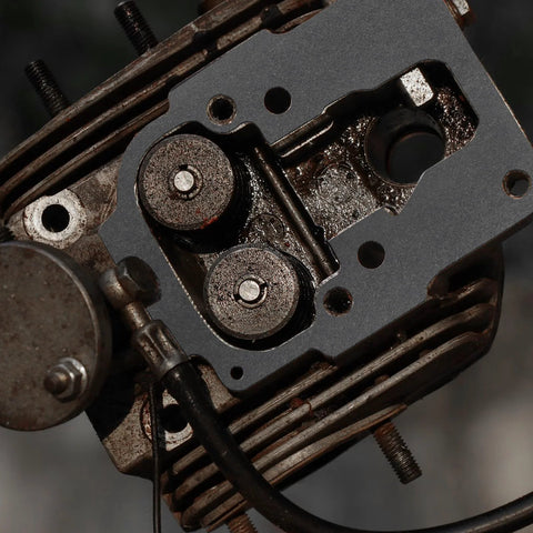 Close-up view of automotive engine cylinder head with gasket surface and valve seats.