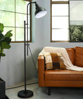Tall Industrial Floor Lamp With Adjustable Height And Head next to orange sofa in living room with large window view