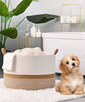 Large Cotton Rope Blanket Basket For Nursery And Living Room Storage Woven Laundry Hamper And Toy Chest 20 By 13 Inches White And Brown Durable Handmade Cotton Rope Basket That Holds Blankets Toys Pillows And Laundry Neatly In Any Room with a cute puppy sitting nearby in a bathroom setting.