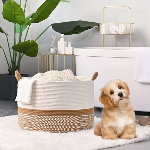 Large Cotton Rope Blanket Basket For Nursery And Living Room Storage Woven Laundry Hamper And Toy Chest 20 By 13 Inches White And Brown Durable Handmade Cotton Rope Basket That Holds Blankets Toys Pillows And Laundry Neatly In Any Room with a cute puppy sitting nearby in a bathroom setting.