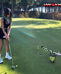 Woman practicing golf with a putter on a green with a Two Pack Golf Ball Basket With Handle, Portable Stainless Steel Buckets nearby