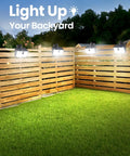 Super Bright 176 Lumen Solar Clip On Fence Lights With Motion Sensor illuminating a backyard with wooden fencing.