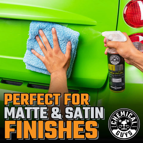 Hand applying Meticulous Matte Detailer And Spray Sealant For Crisp Satin And Matte Finishes Safe For OEM Vinyl And Painted Matte Surfaces 32 Fl Oz Easy Spray Application Non Greasy Matte Coating Streak Free Protection For Your Daily Driver to green car with cloth