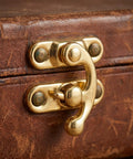 Close-up of vintage swing lock clasp on a suitcase, part of Old School Antique Style Hasps And Latches Set For Cabinets And Jewelry Boxes