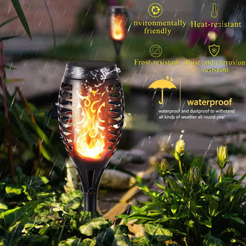 Outdoor Halloween Lights Four Pack LED Torch Lanterns with Flickering Flame Effect in garden setting under rain.